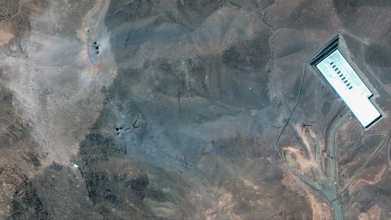 A handout satellite image made available by Maxar Technologies shows a closer view of craters and ash on a ridge at the Fordo underground uranium enrichment following US airstrikes, in Iran