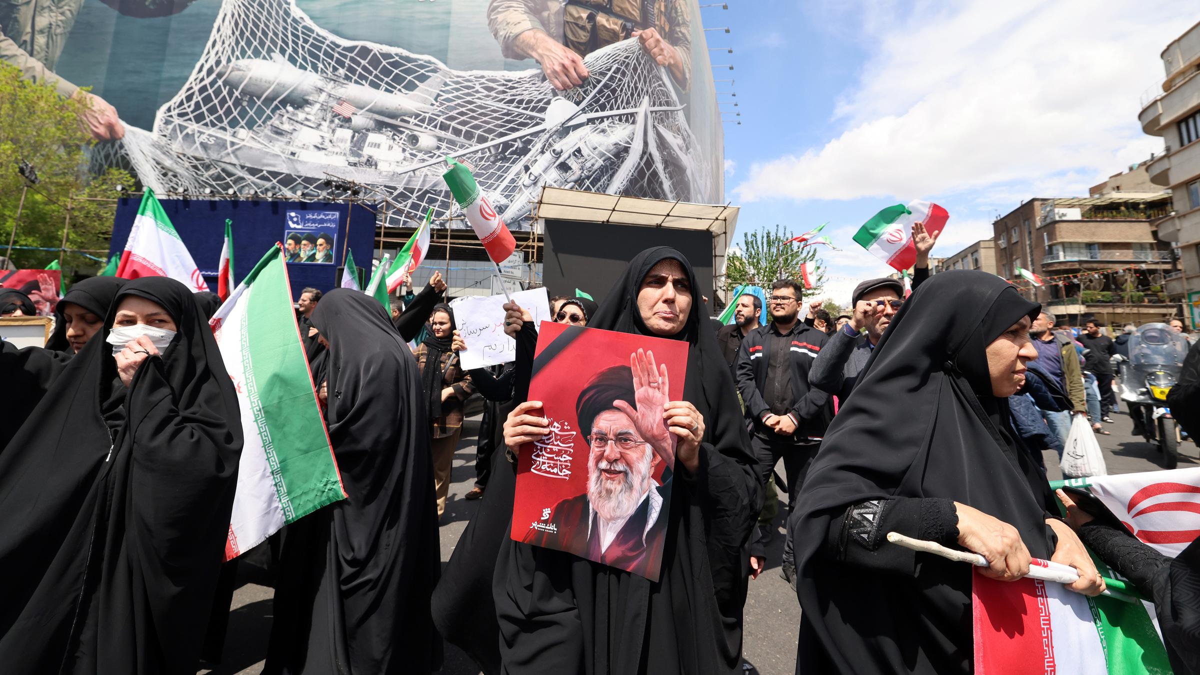 Menschen versammeln sich auf einem Platz in Teheran nach der Verkündung der Feuerpause mit den USA.