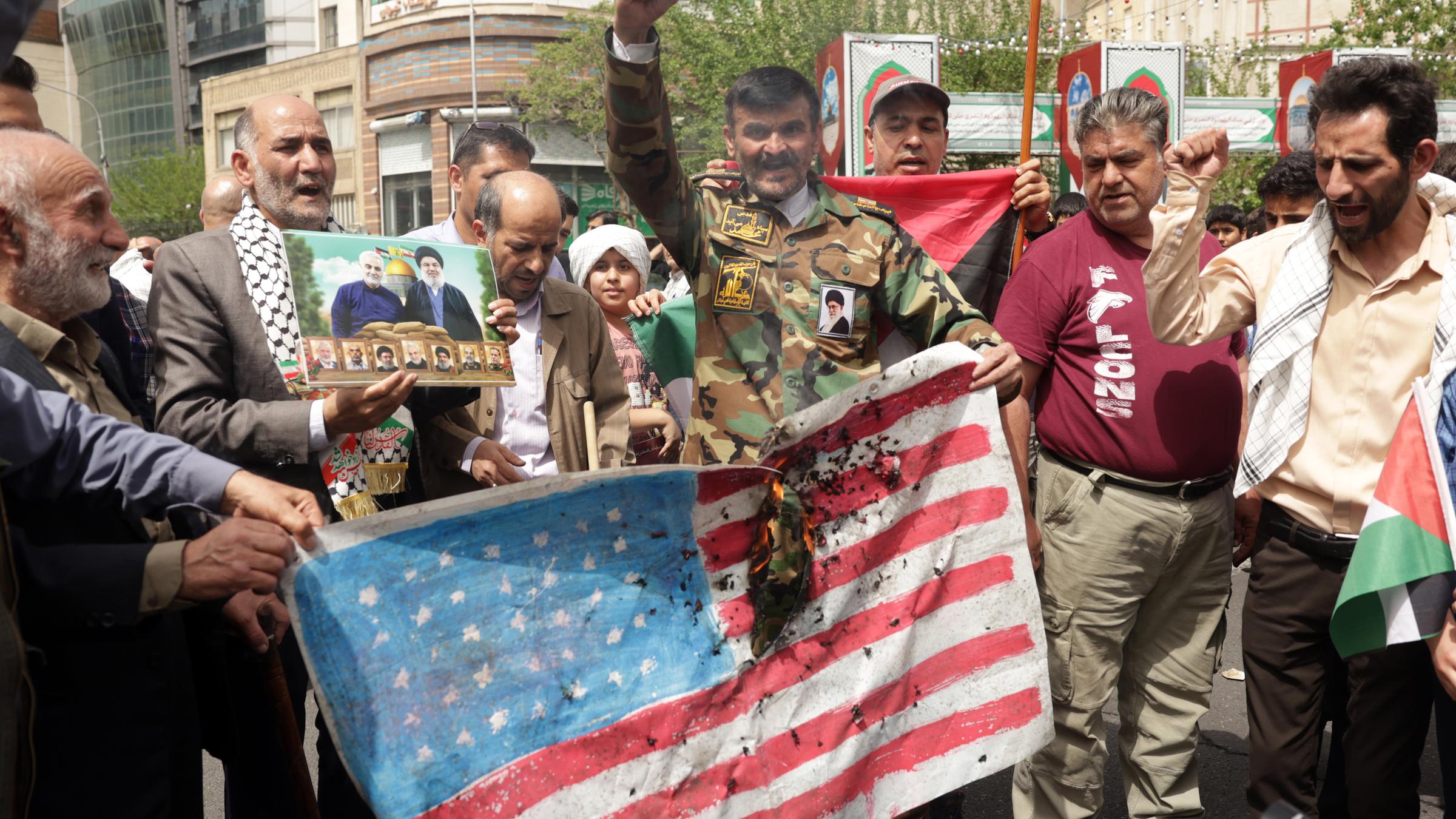Iraner verbrennen eine US-Flagge, während sie an einer anti-israelischen Protestkundgebung auf dem Palästina-Platz in Teheran, Iran