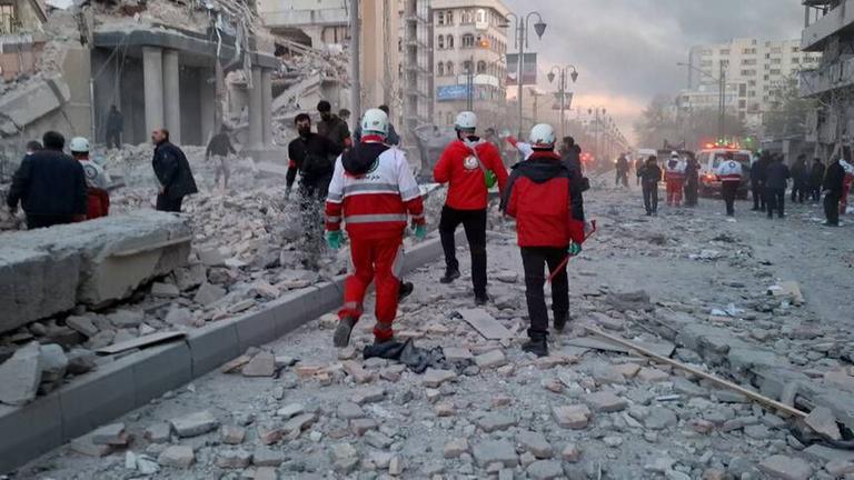Mitglieder eines Rettungsteams arbeiten an einem durch Luftangriffe beschädigten Gebäude in Iran.