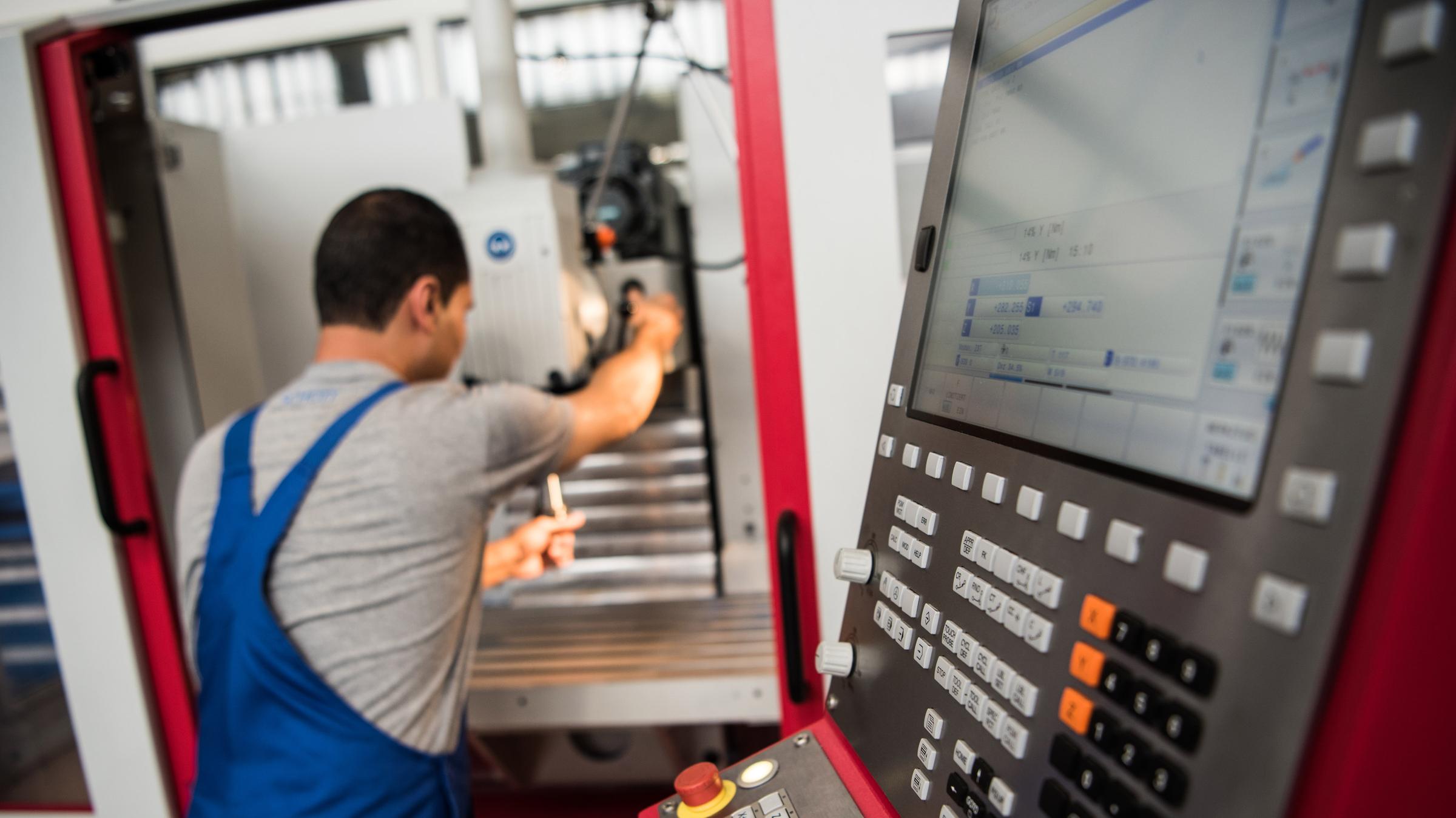 Archiv: ein auszubildender, der 2012 aus dem iran nach deutschland geflohen war, setzt ein werkzeug in eine fraesmaschine ein.