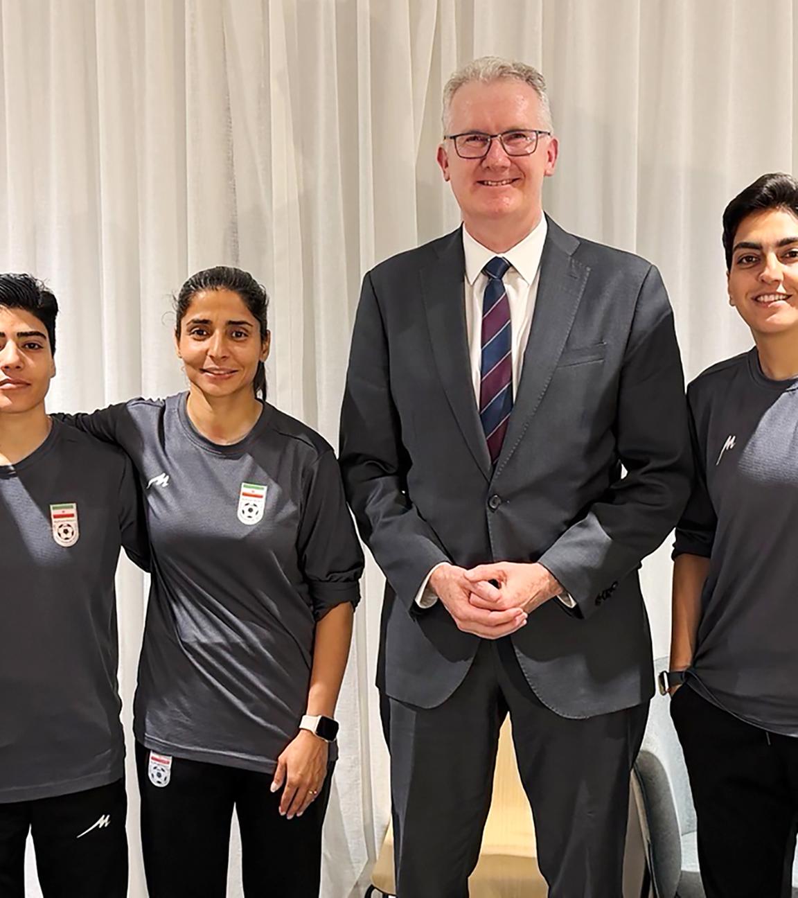 Australischer Innenministers Tony Burke posiert am 10.03.2026 mit fünf iranischen Fußballspielerinnen, denen in Australien Asyl gewährt wurde