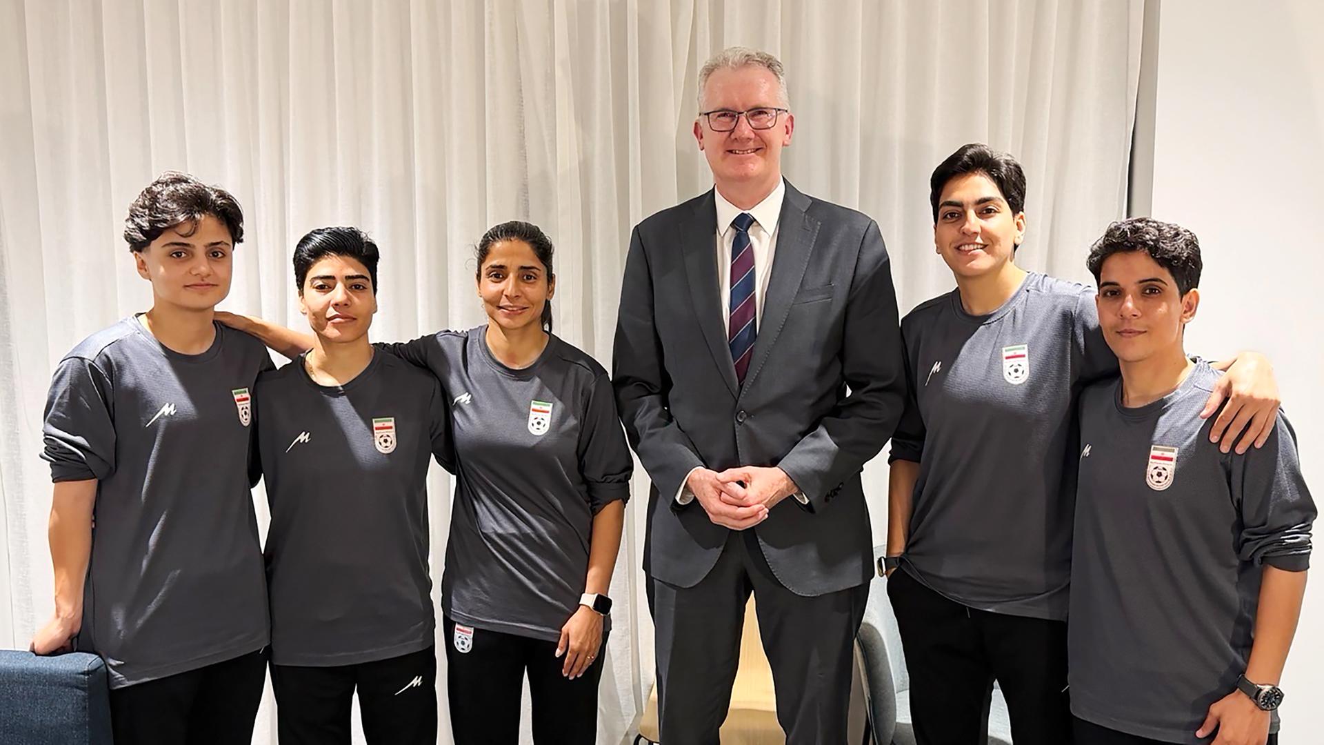 Australischer Innenministers Tony Burke posiert am 10.03.2026 mit fünf iranischen Fußballspielerinnen, denen in Australien Asyl gewährt wurde