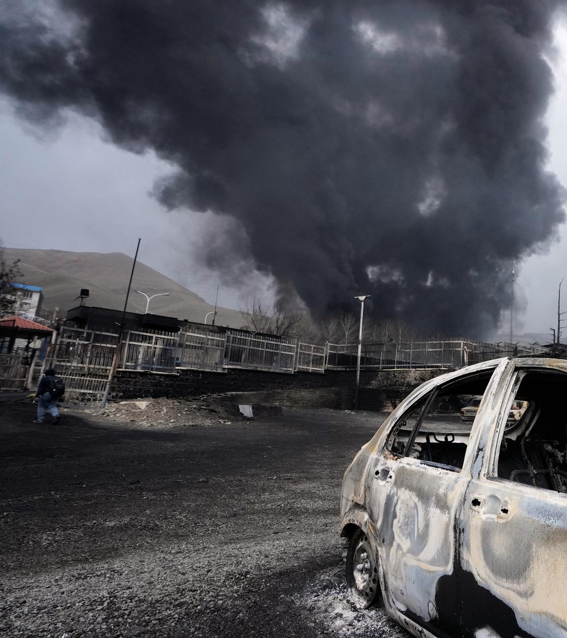 Iran, Teheran: Eine dicke Rauchwolke steigt aus einem Öllager auf.