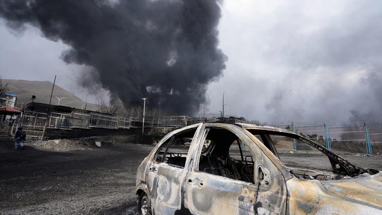 Iran, Teheran: Eine dicke Rauchwolke steigt aus einem Öllager auf.