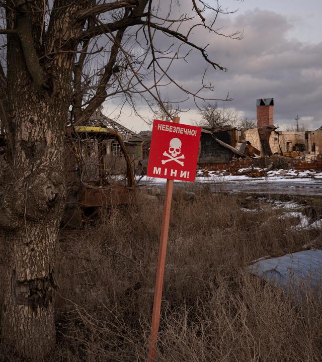Ein Schild mit der Aufschrift "Minen" steht am Straßenrand des Dorfes Kamjanka am Rande von Isjum.