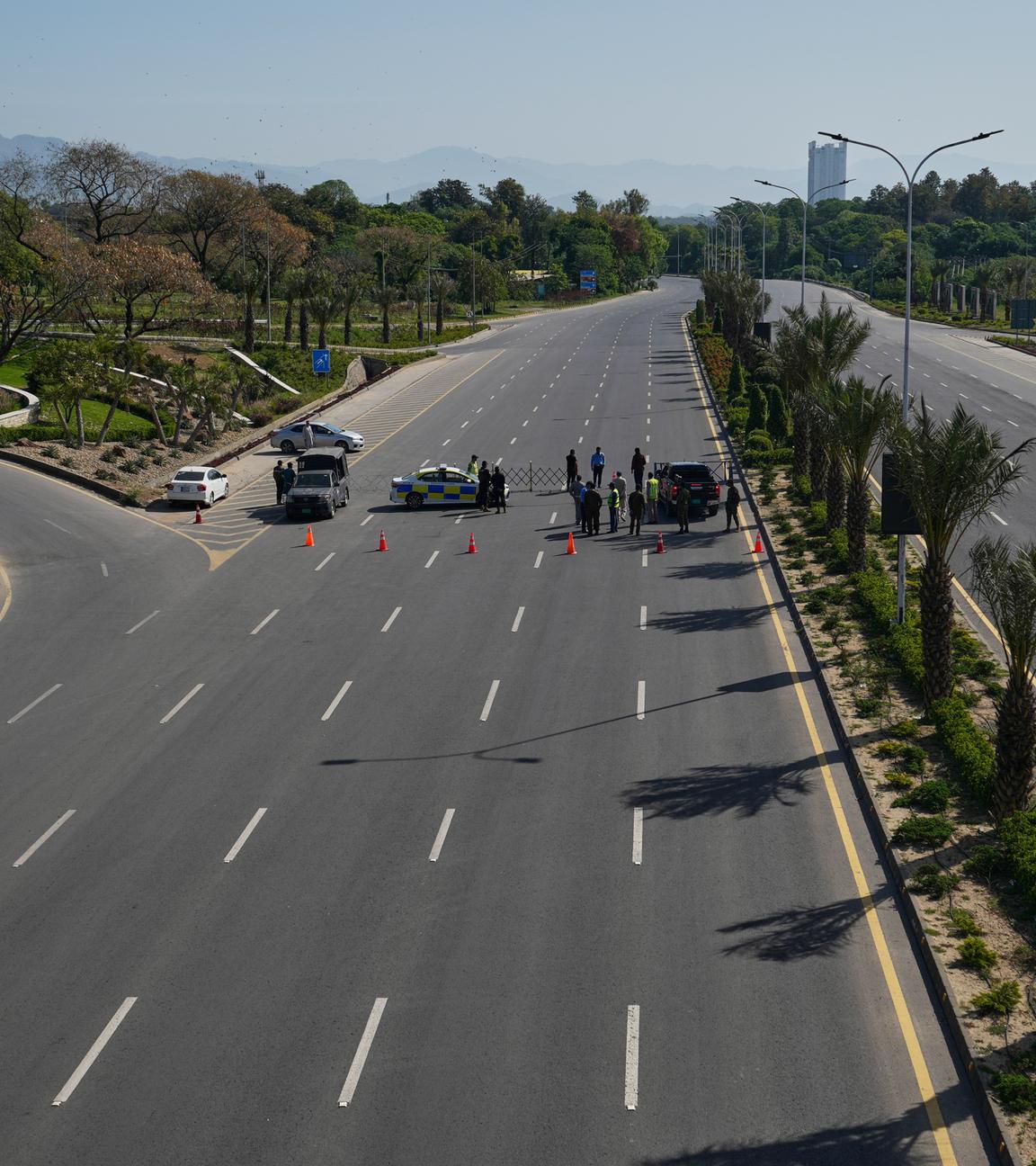 Polizeibeamte stehen an einem Kontrollpunkt auf einer verbarrikadierten Straße Wache, um die Sicherheit vor der zweiten Verhandlungsrunde zwischen den USA und dem Iran zu gewährleisten, in Islamabad, Pakistan.