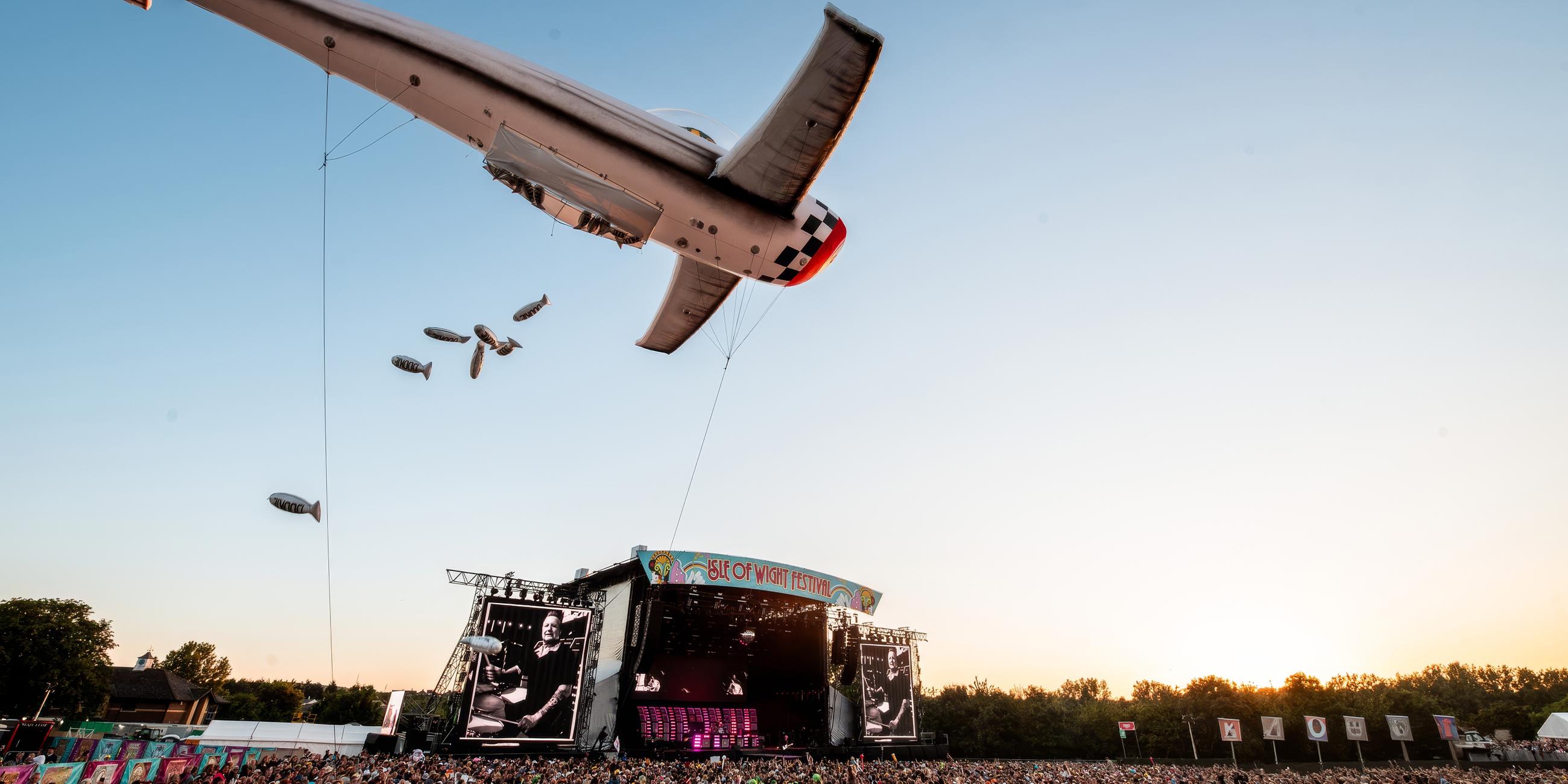 Ein riesiger Flugzeug-Luftballon fliegt über die Menge vor der Festivalbühne.