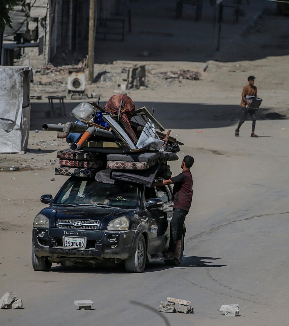 Eine Auto mit Habseligkeiten auf dem Dach festgeschnürt fährt durch Gaza-Stadt.