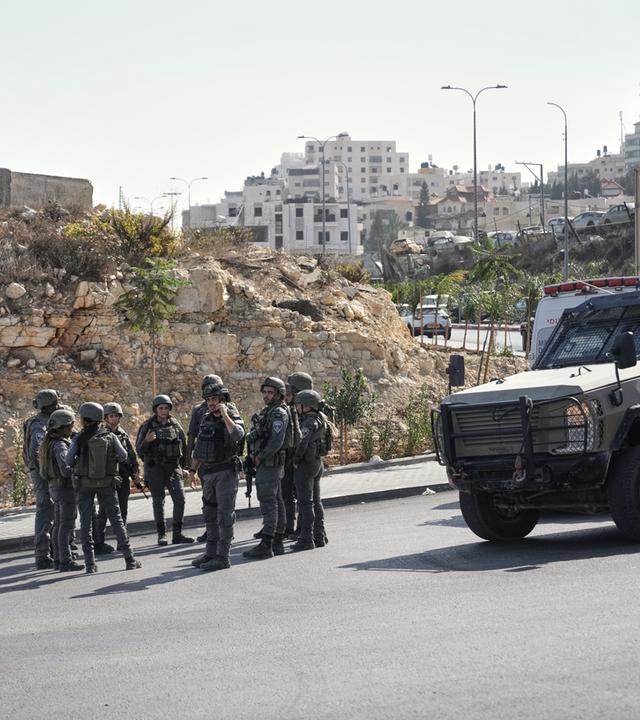 Israelische Soldaten versammeln sich am Ort eines Schussangriffs, den palästinensische Bewaffnete an einer Kreuzung in der Nähe von Hebron im besetzten Westjordanland verübt haben.