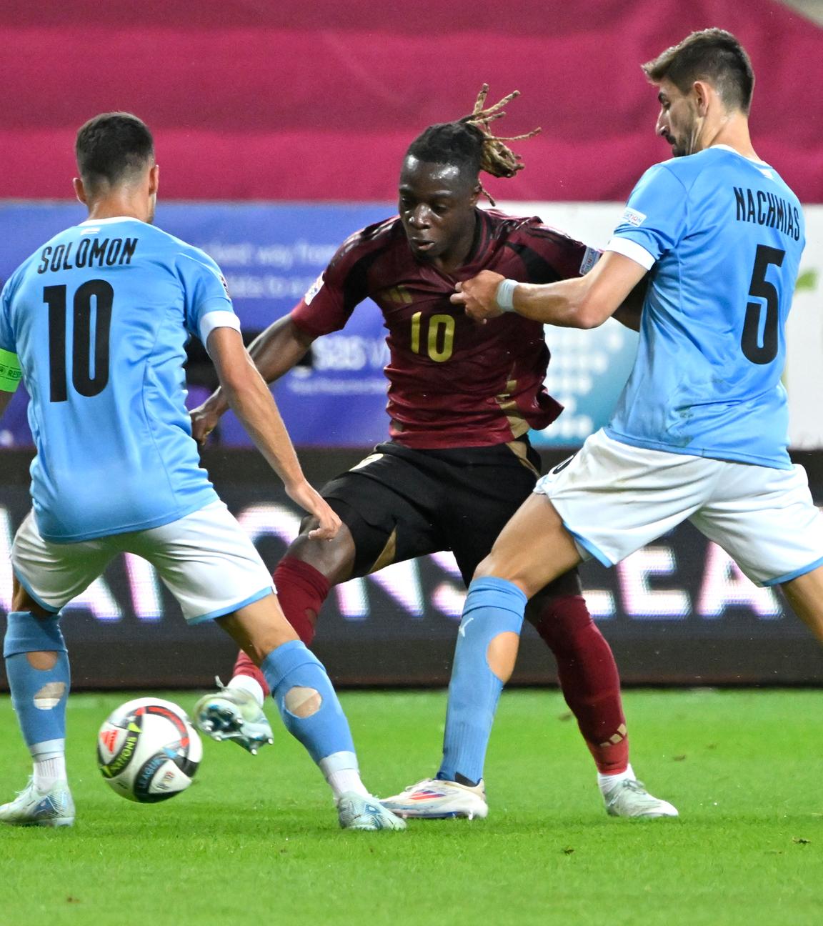 Die israelischen Spieler Idan Nachmias und Manor Solomon im Ballkampf mit Belgiens Jeremy Doku.