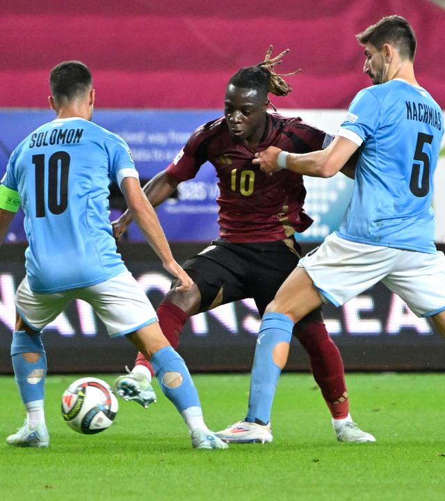 Die israelischen Spieler Idan Nachmias und Manor Solomon im Ballkampf mit Belgiens Jeremy Doku.