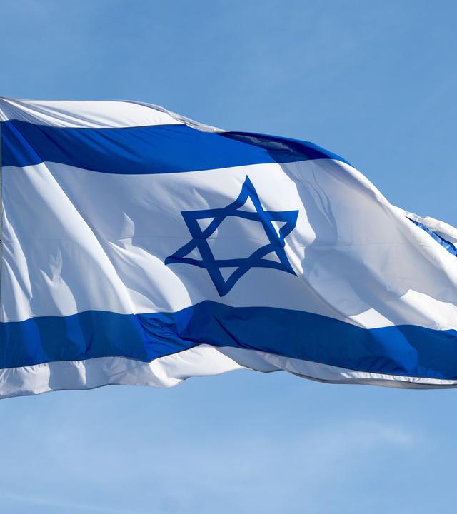 Die Flagge von Israel weht vor blauem Himmel.
