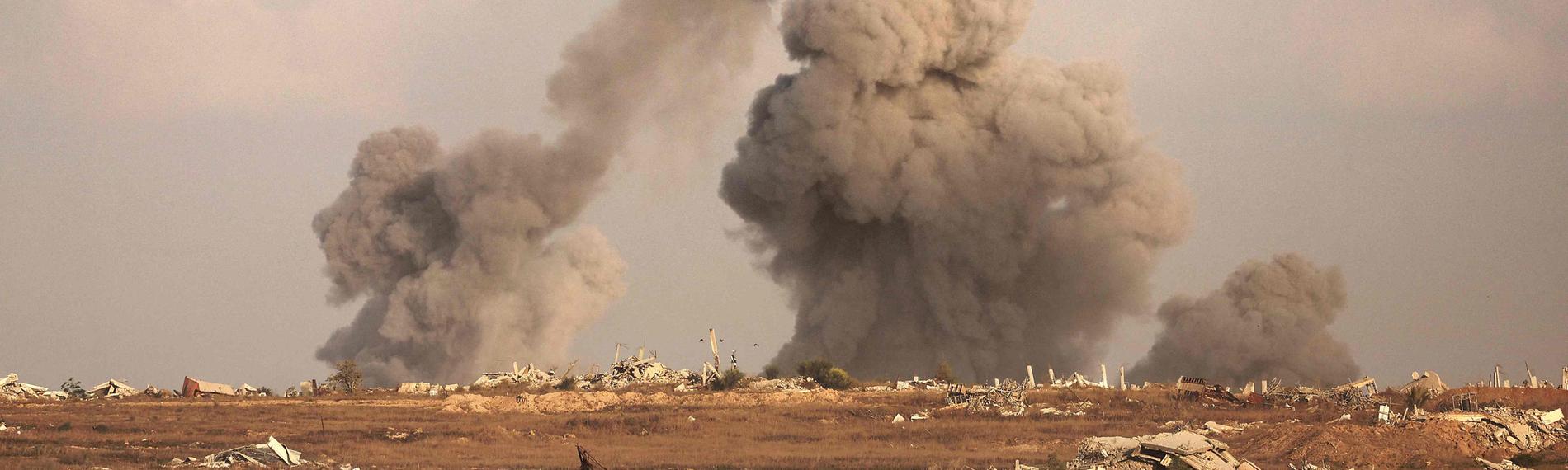 Eine Totalaufnahme einer zerstörten Landschaft in Gaza, Rauch steigt herab.