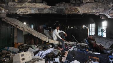 Ein palästinensischer Mann istzt auf Trümmern in der zerstörten Fahmi Al-Jarjawi Schule in Gaza-Stadt im Gazastreifen. Die Schule, die als Notunterkunft genutzt wurde, wurde bei einem israelischen Luftangriff zerstört.