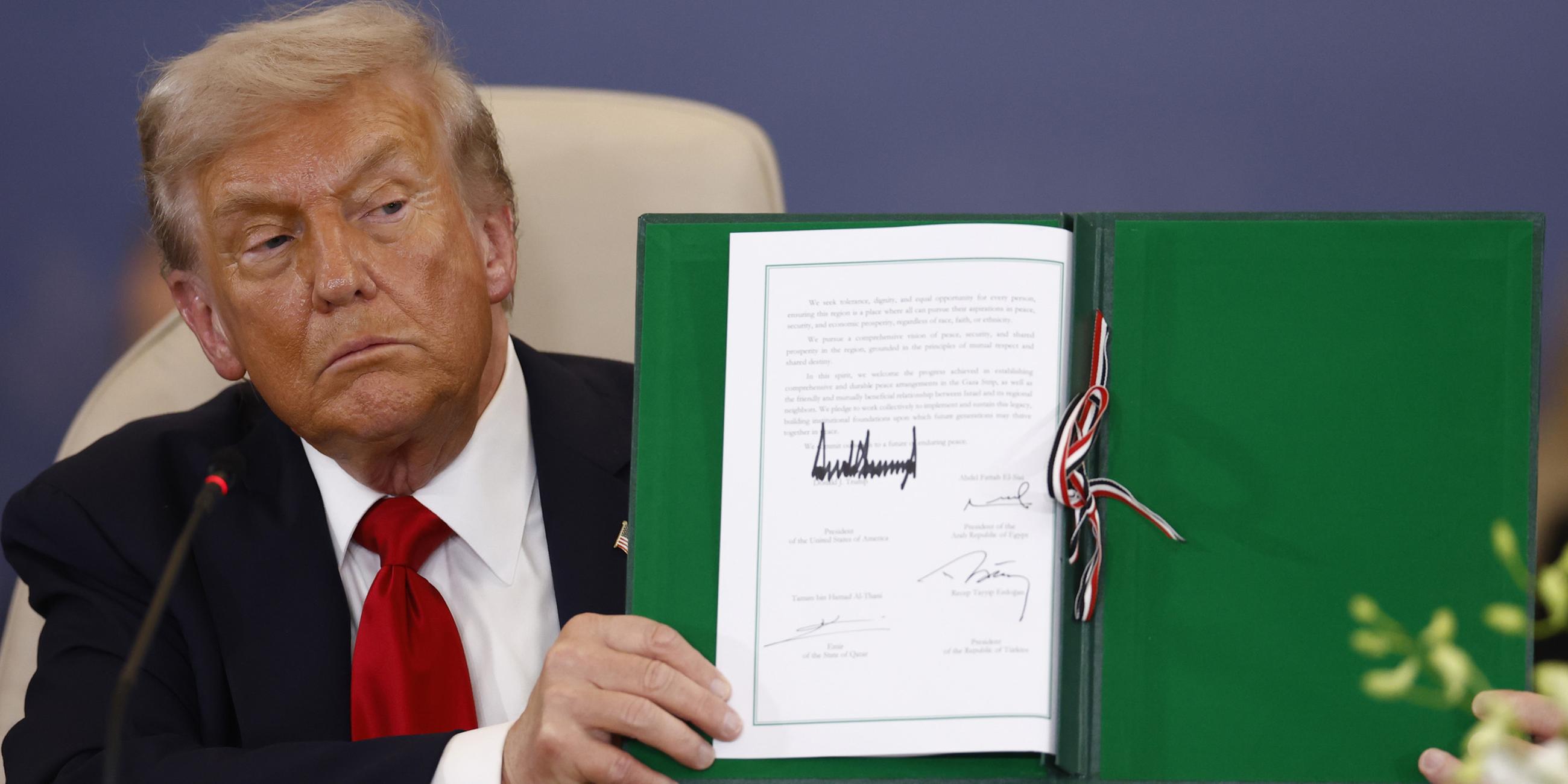 US-Präsident Donald Trump zeigt ein unterzeichnetes Dokument bei der Friedensgipfel-Zeremonie in Scharm el-Scheich, Ägypten, am 13. Oktober 2025.