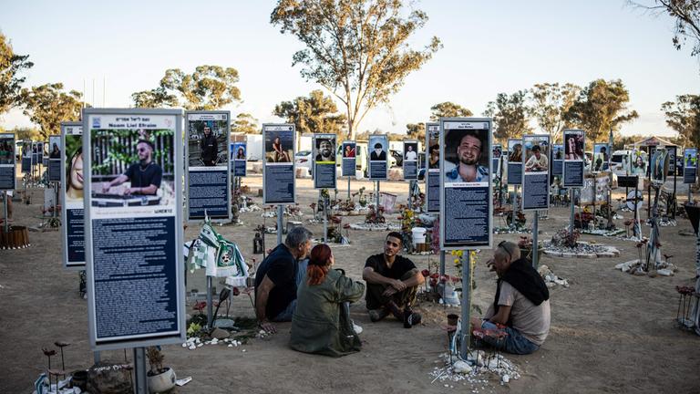 Re'im, Israel: Eine Familie sitzt an einem Denkmal an dem Ort, wo das Nova Festival 2023 stattgefunden hat.