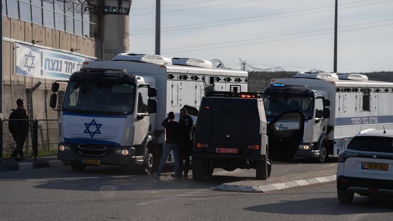 Es sind Gefangenentransportbusse vor einem israelischen Gefängnis zu sehen. Auf ihnen ist die israelische Flagge zu erkennen.