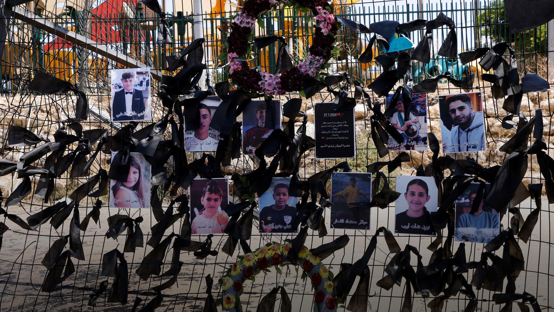 Die Bilder der bei einem Raketenanschlag auf den Golanhöhen getöteten Kinder hängen am Zaun eines Fußballplatzes
