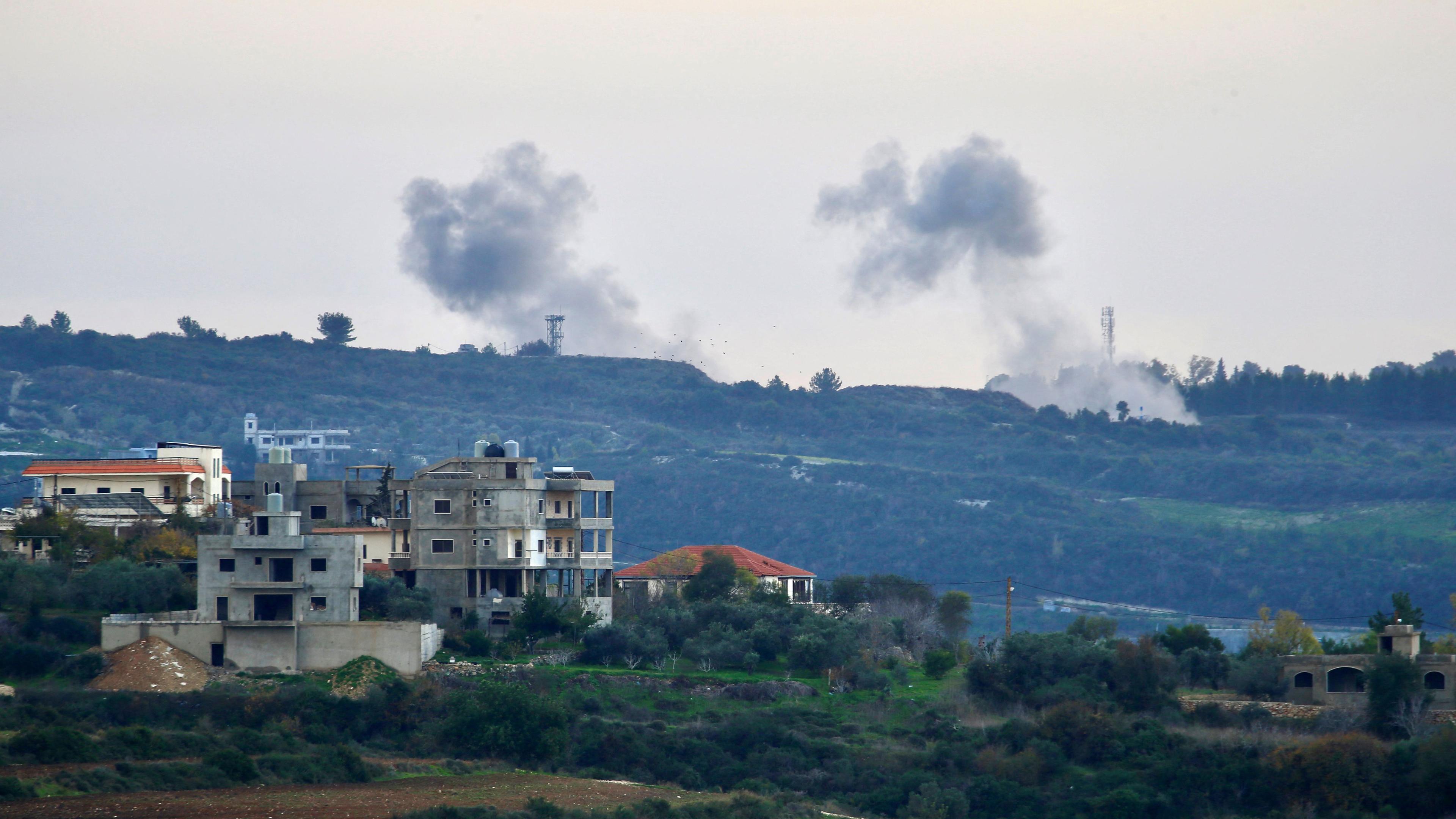 LEBANON-südlibanesischen Dorf Dhayra an der israelischen Grenze aufgenommene Foto zeigt Gebäude in der libanesischen Stadt Tair Harfa, während Rauch über dem Norden Israels aufsteigt-PALESTINIAN-CONFLICT