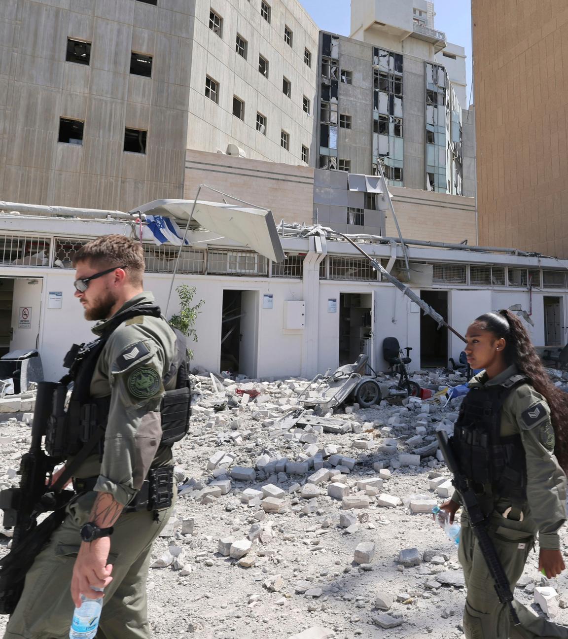Soldaten gehen vor dem Soroka Medical Center, nachdem es am Donnerstag, den 19. Juni 2025 von einer aus dem Iran abgefeuerten Rakete getroffen wurde. 