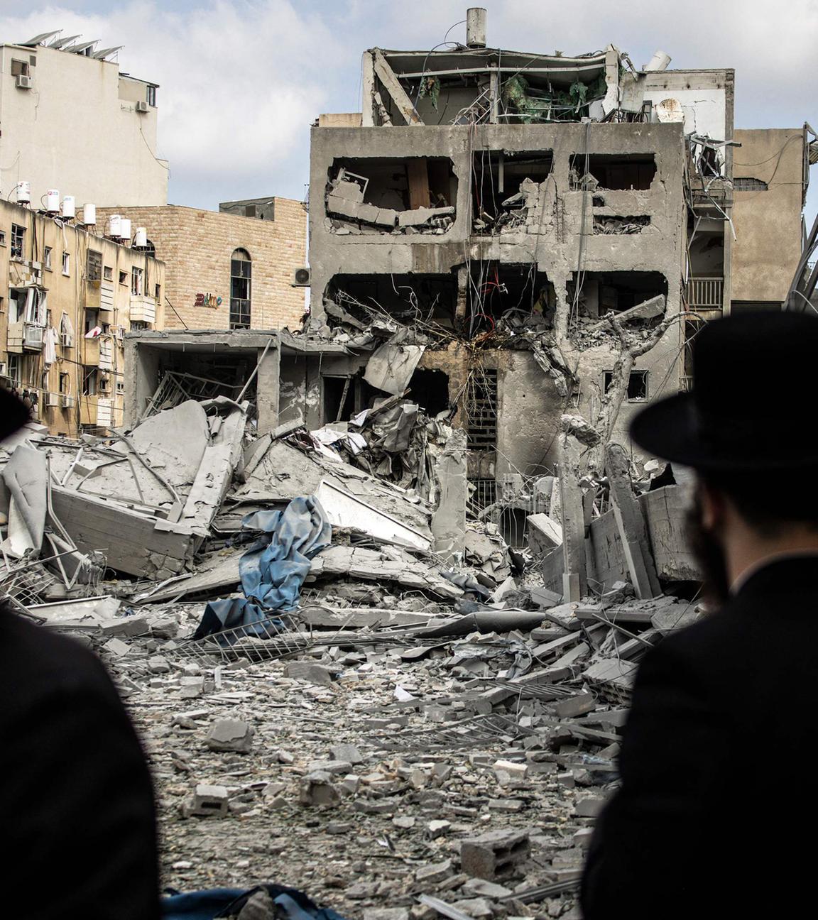 Orthodoxe Männer stehen vor zerstörten Häusern in Bnei Brak, Israel