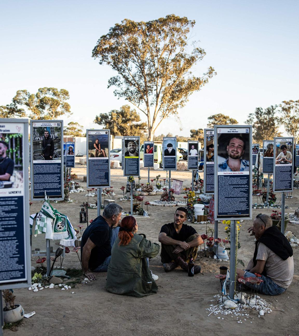 A family sits to a memorial of one of the victims of the 2023 October 7 attacks at the Nova Festival grounds in Reim in southern Israel on the second anniversary of the attacks on October 7, 2025. 