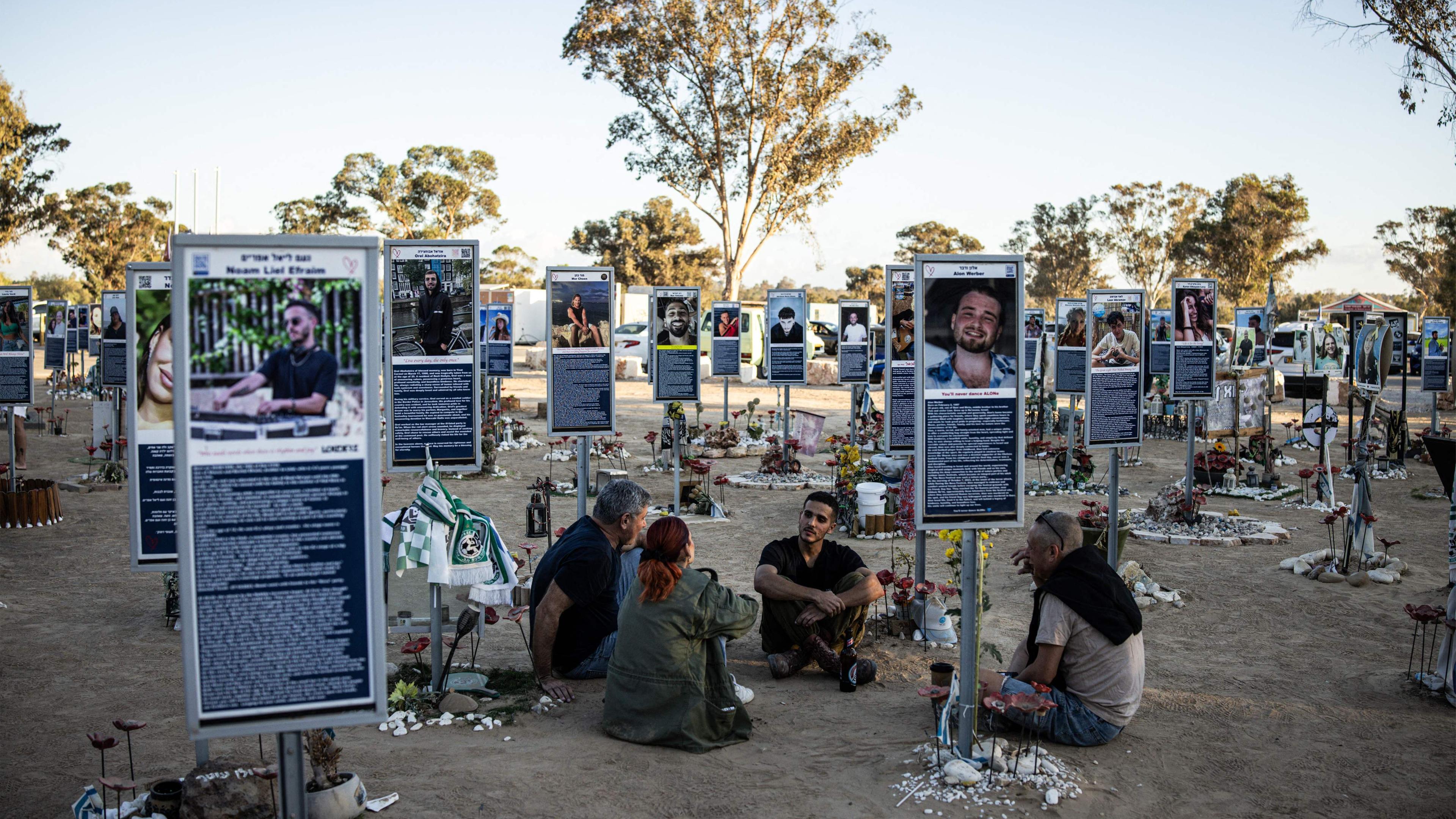 A family sits to a memorial of one of the victims of the 2023 October 7 attacks at the Nova Festival grounds in Reim in southern Israel on the second anniversary of the attacks on October 7, 2025. 