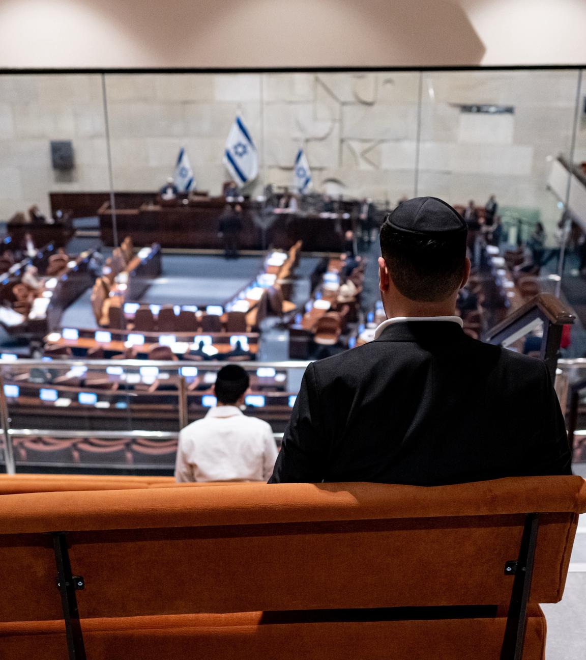 Ein Besucher (von hinten zu sehen) verfolgt die Debatte in der Knesset.