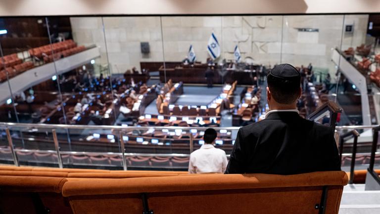 Ein Besucher (von hinten zu sehen) verfolgt die Debatte in der Knesset.