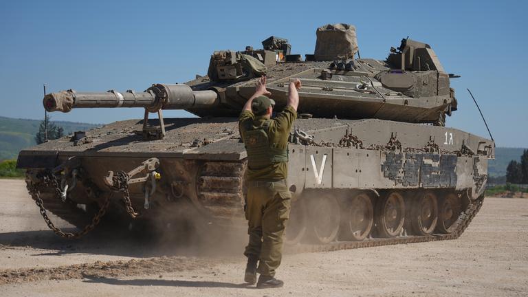  Ein israelischer Soldat steht vor einem Panzer.