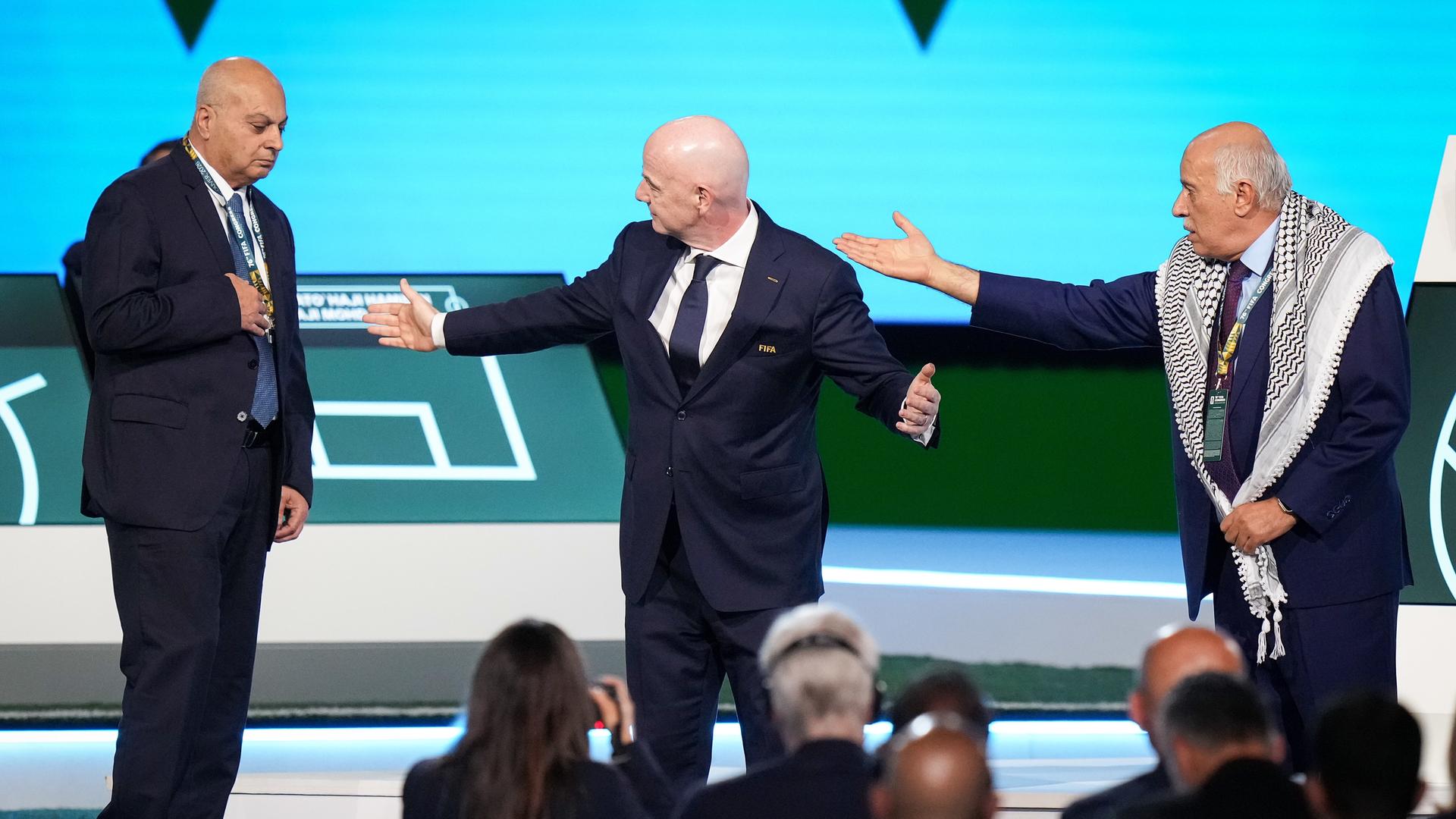 Der Chef des palästinensischen Fußball-Verbandes Jibril Rajoub (rechts) deutet auf Basim Sheikh Suliman, Chef des israelischen Verbandes. In der Mitte versucht FIFA-Präsident Gianni Infantino zu beschwichtigen.