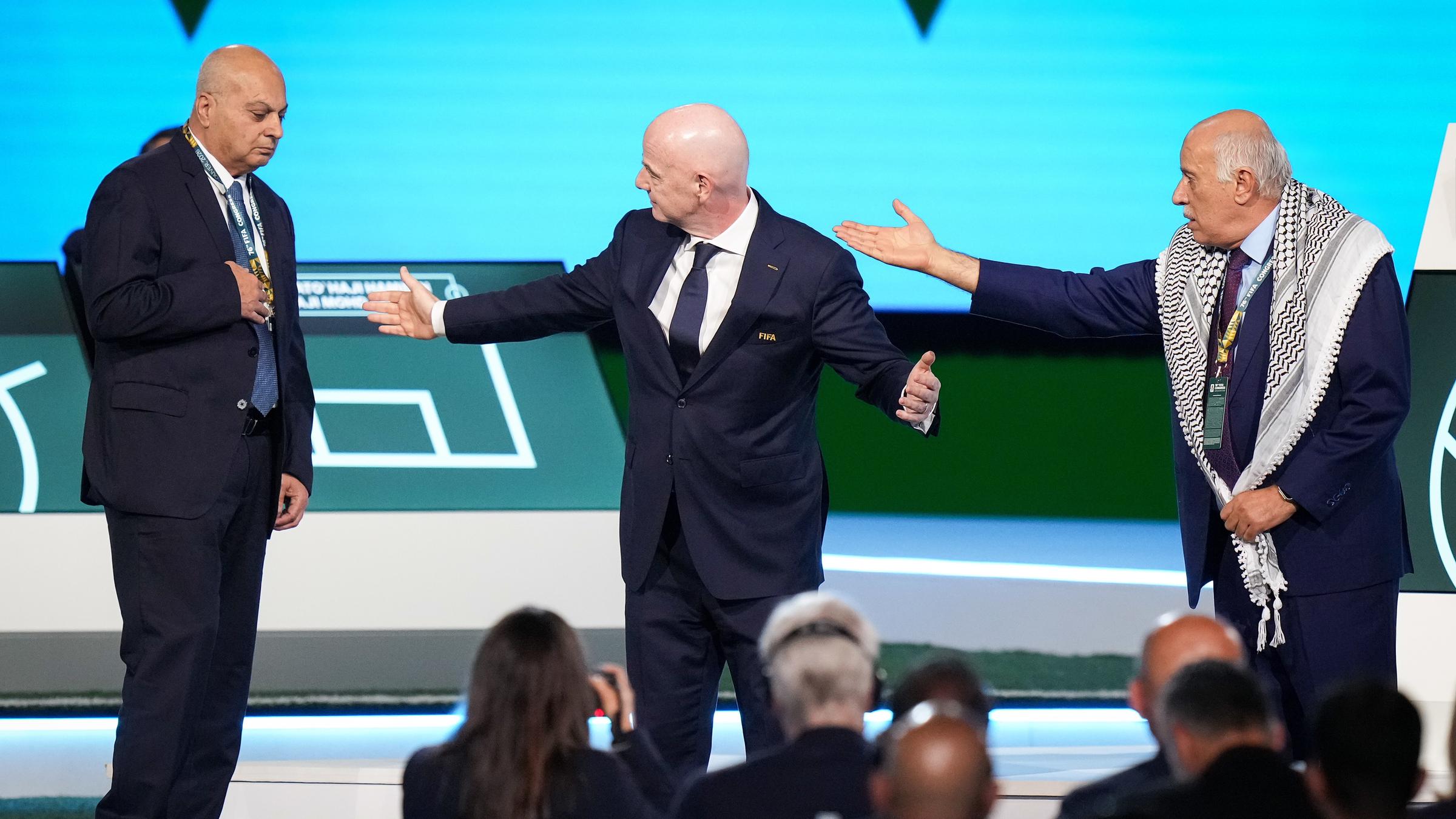 Der Chef des palästinensischen Fußball-Verbandes Jibril Rajoub (rechts) deutet auf Basim Sheikh Suliman, Chef des israelischen Verbandes. In der Mitte versucht FIFA-Präsident Gianni Infantino zu beschwichtigen.