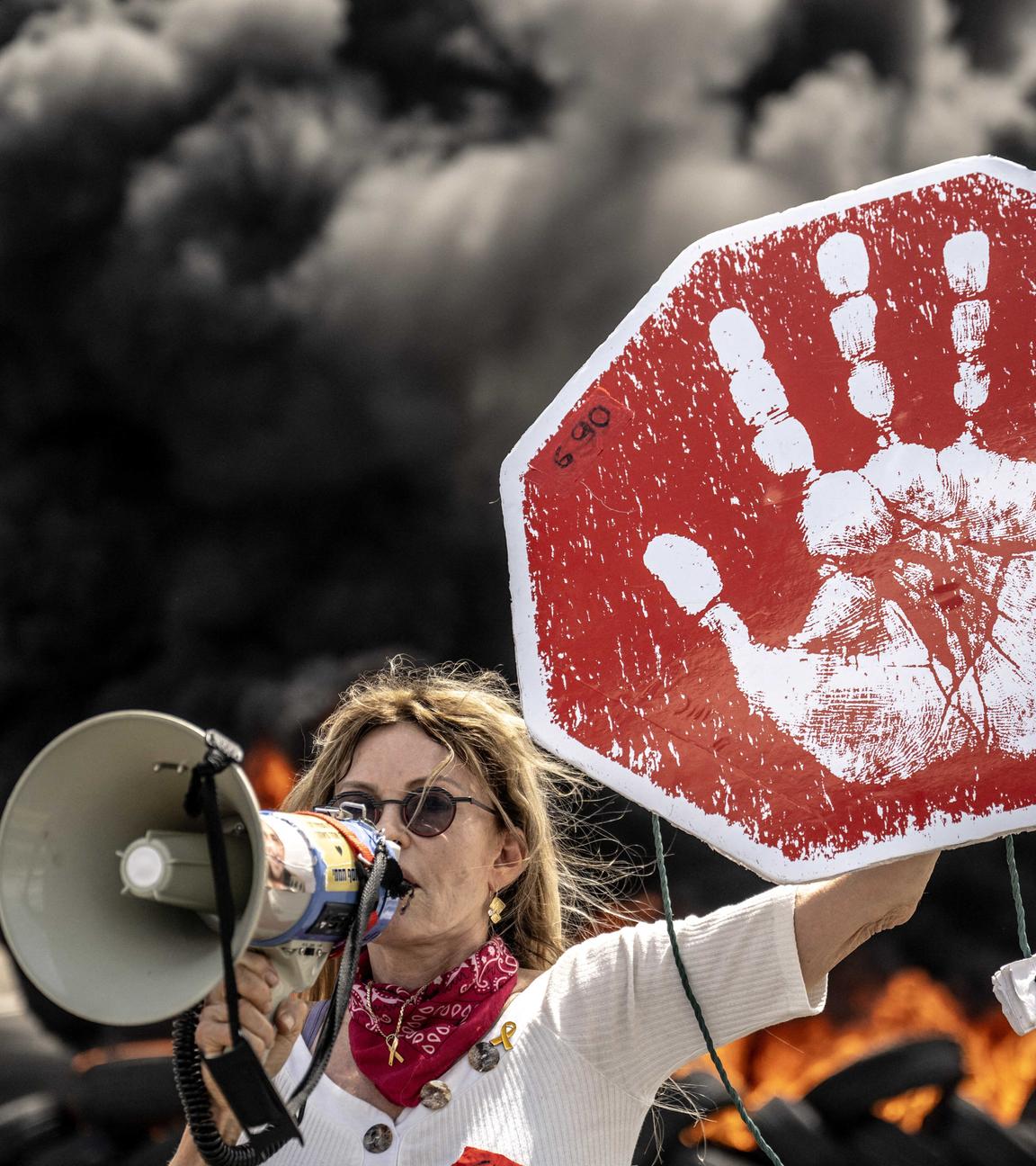  Israeli protesters hold banners and block the road during the demonstration demanding an agreement for the release of Israeli hostages in Gaza.