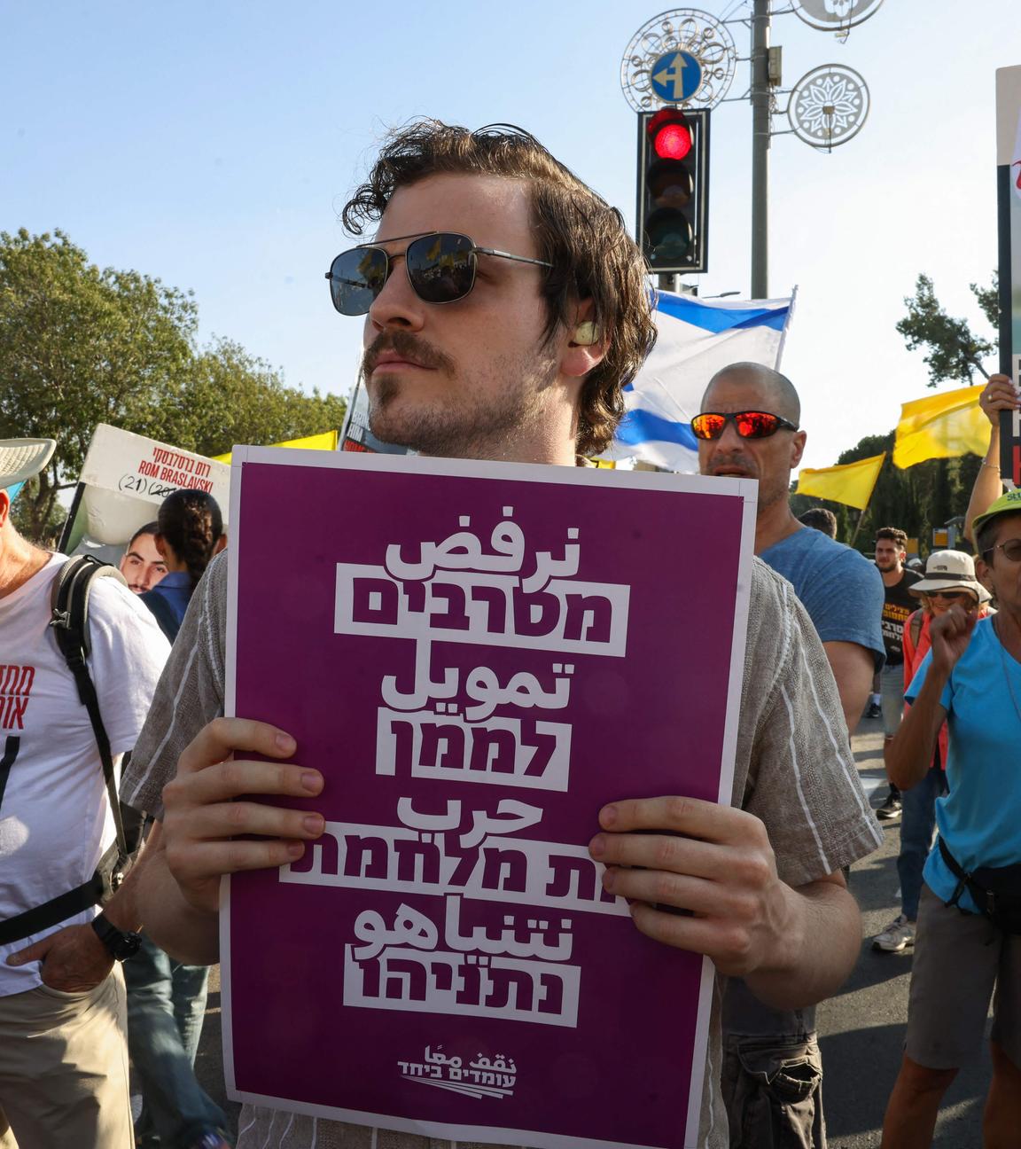 Protesters lift placards during a rally calling for an end of the war in Gaza and a return of Israelis held hostage since 2023 in the besieged Palestinian territory, in front of the prime minister's office in Jerusalem on August 26, 2025. 