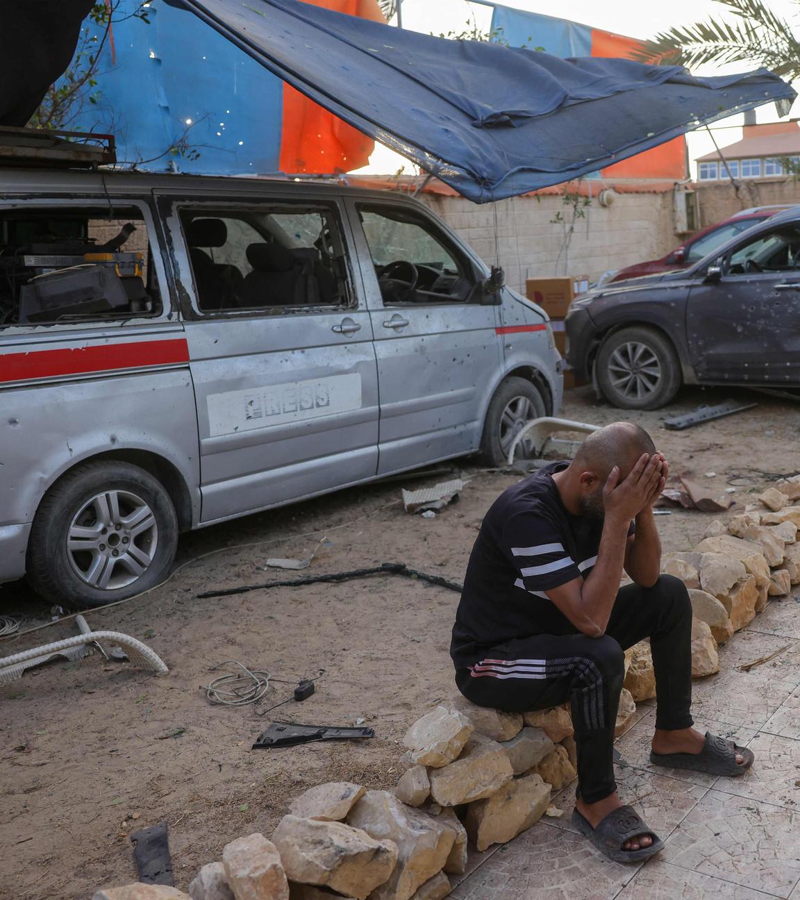 Dieses Bild zeigt ein beschädigtes Fahrzeug und einen trauernden Mann nach einem israelischen Angriff, der Berichten zufolge am 19.10.2025 ein von Journalisten genutztes Haus in der Stadt Al-Zawayda in der Nähe von Deir al-Balah im Zentrum des Gazastreifens getroffen hat. 