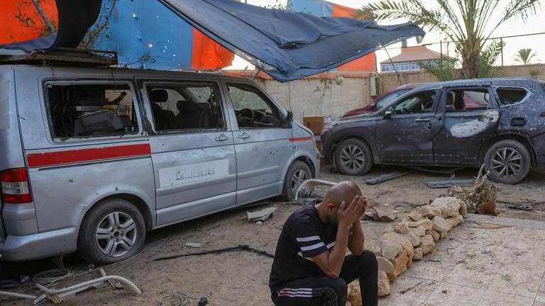 Dieses Bild zeigt ein beschädigtes Fahrzeug und einen trauernden Mann nach einem israelischen Angriff, der Berichten zufolge am 19.10.2025 ein von Journalisten genutztes Haus in der Stadt Al-Zawayda in der Nähe von Deir al-Balah im Zentrum des Gazastreifens getroffen hat. 