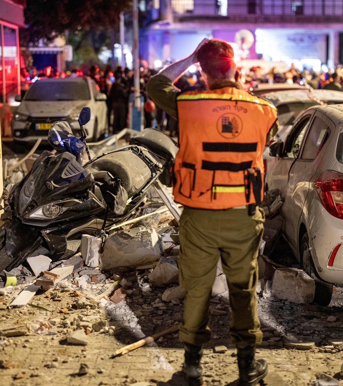 Israel, Ramat Gan: Israelische Polizeibeamte und Rettungskräfte arbeiten am Tatort eines Wohnhauses am Stadtrand von Tel Aviv, das von einer iranischen Rakete getroffen wurde.