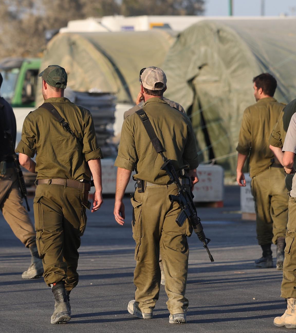 Israelische Reservesoldaten gehen an Militärzelten einer Rekrutierungsbasis im Süden Israels vorbei