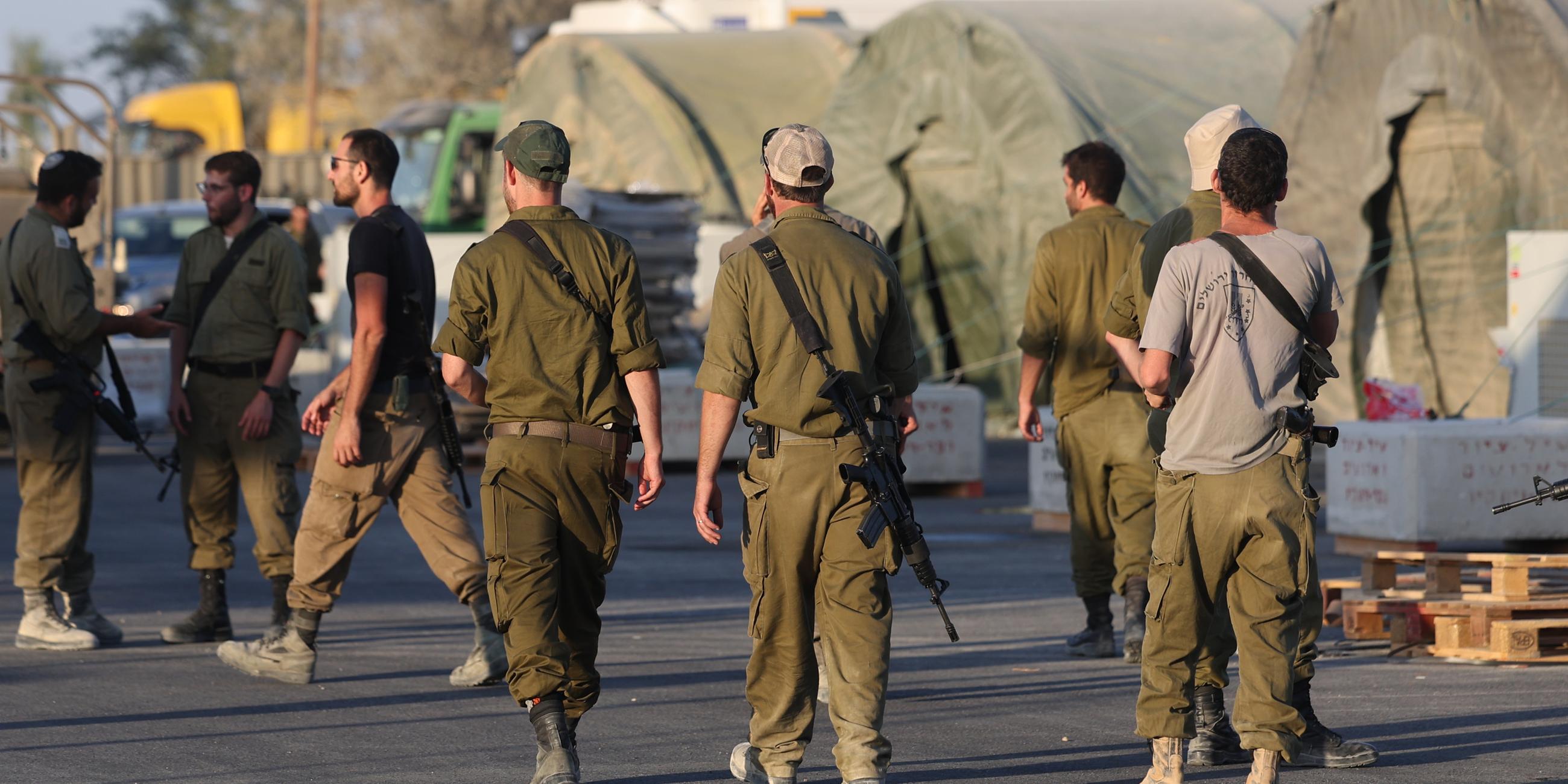 Israelische Reservesoldaten gehen an Militärzelten einer Rekrutierungsbasis im Süden Israels vorbei