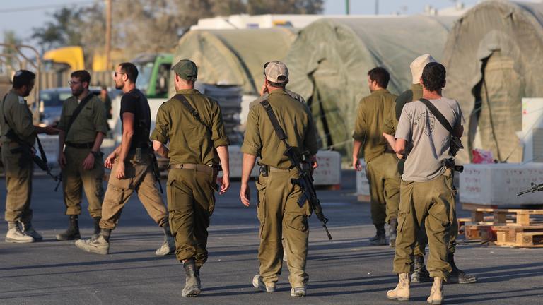 Israelische Reservesoldaten gehen an Militärzelten einer Rekrutierungsbasis im Süden Israels vorbei