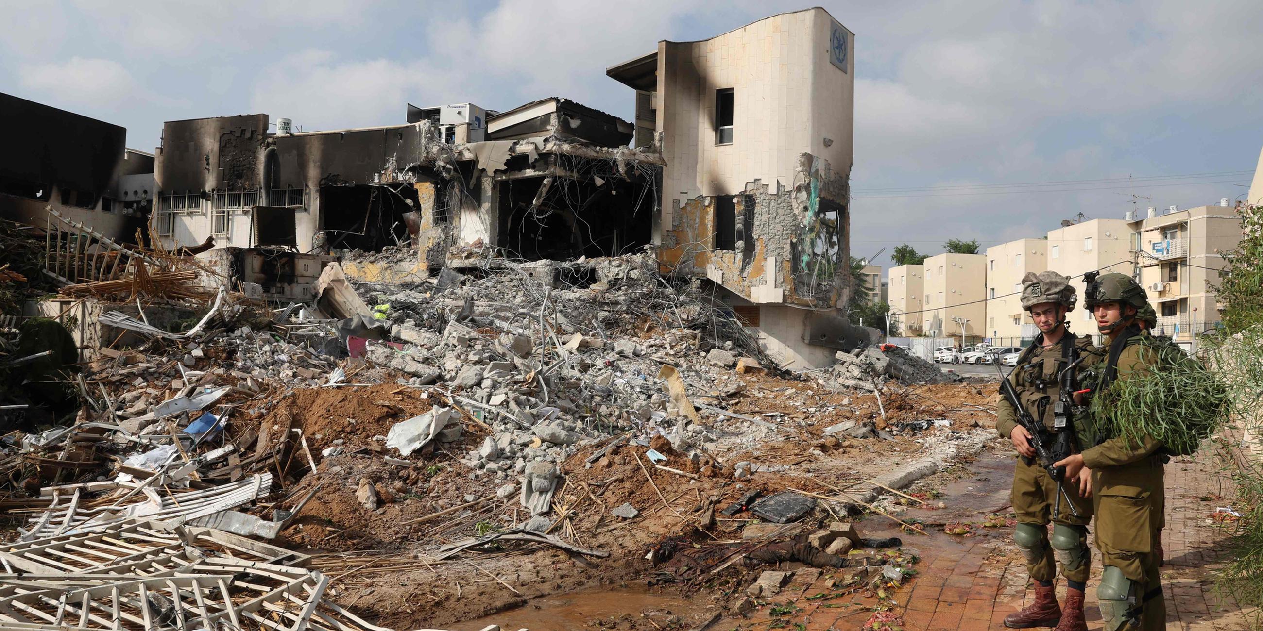 Soldaten stehen am 08.102023 vor einer israelischen Polizeistation, die bei Kämpfen zur Vertreibung der darin stationierten Hamas-Kämpfer beschädigt wurde.