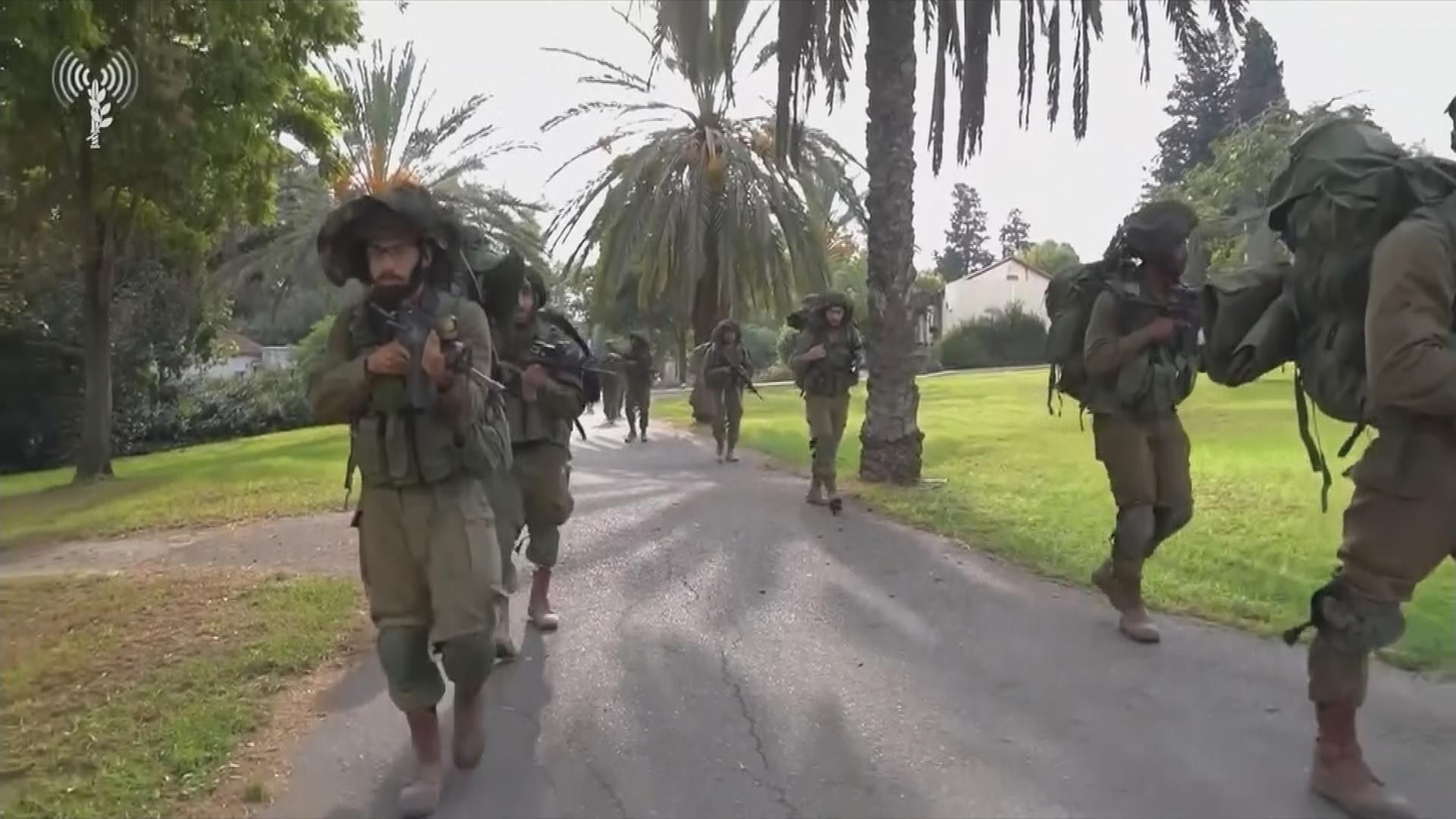 Israelische Soldaten mit Marschgepäck auf einer Straße