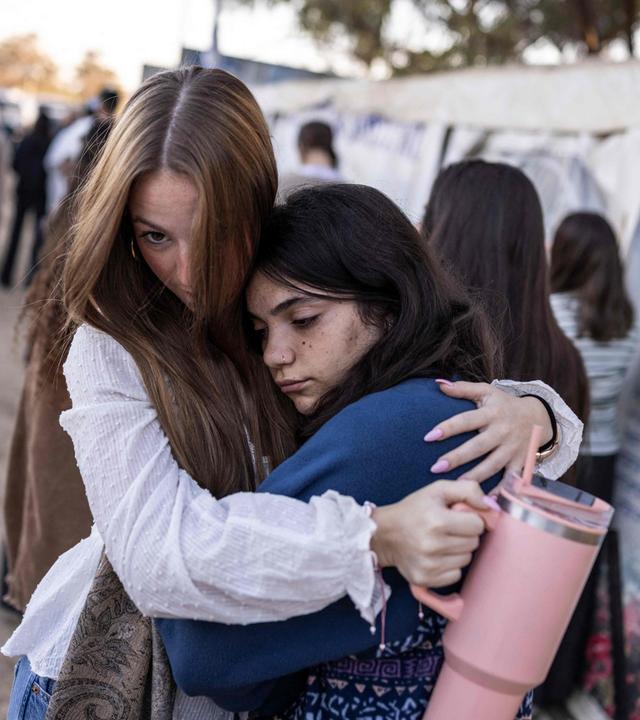 Zwei Frauen umarmen sich auf dem Gedenkplatz des Musikfestivals, das 2023 von der Hamas überfallen wurde.