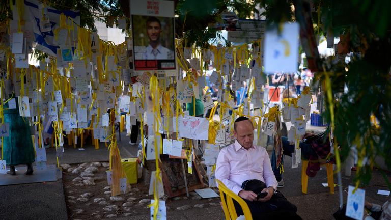 Israel, Tel Aviv: Ein Mann ruht sich auf dem Geiselplatz in Tel Aviv aus.