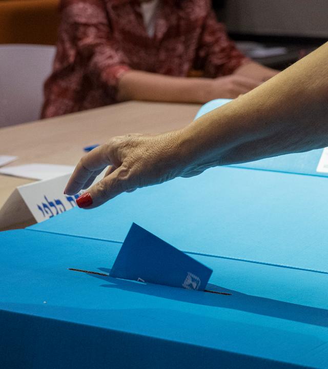 Eine Frau wirft am 27. Oktober im Nation Community Center in Westjerusalem, Israel, einen Wahlumschlag in eine Wahlurne.