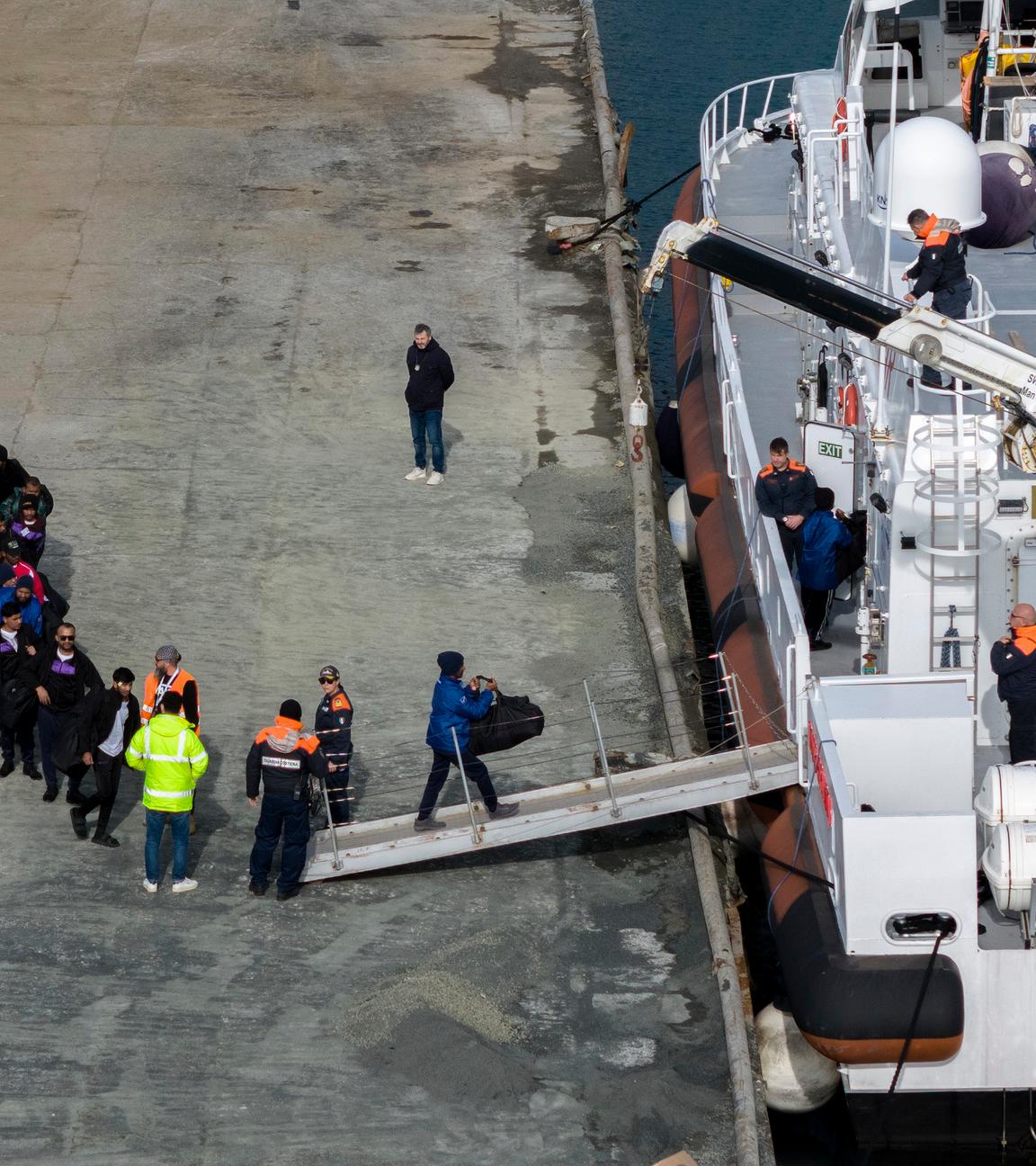 Migranten besteigen im Hafen von Shengjin im Nordwesten Albaniens ein Schiff der italienischen Küstenwache.