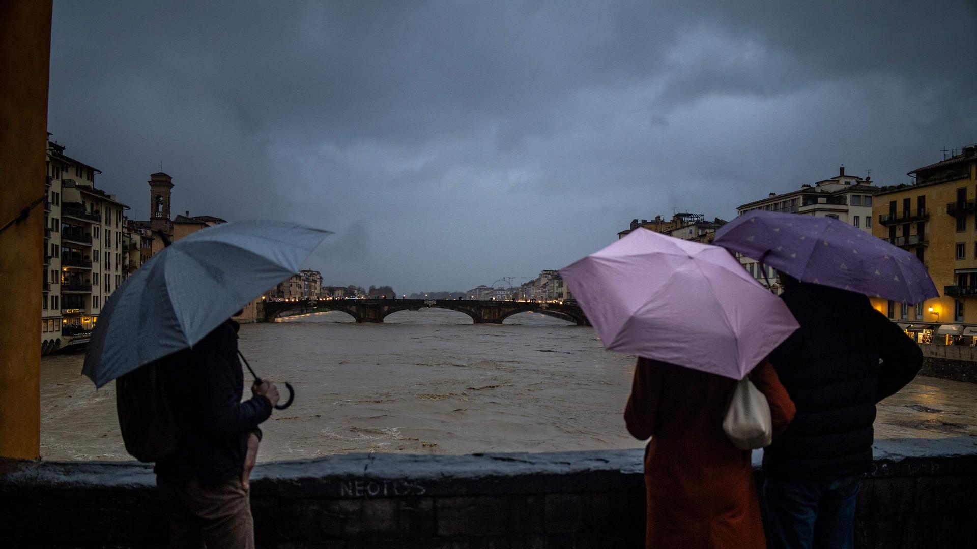 Menschen betrachten den steigenden Pegel des Flusses Arno in Florenz