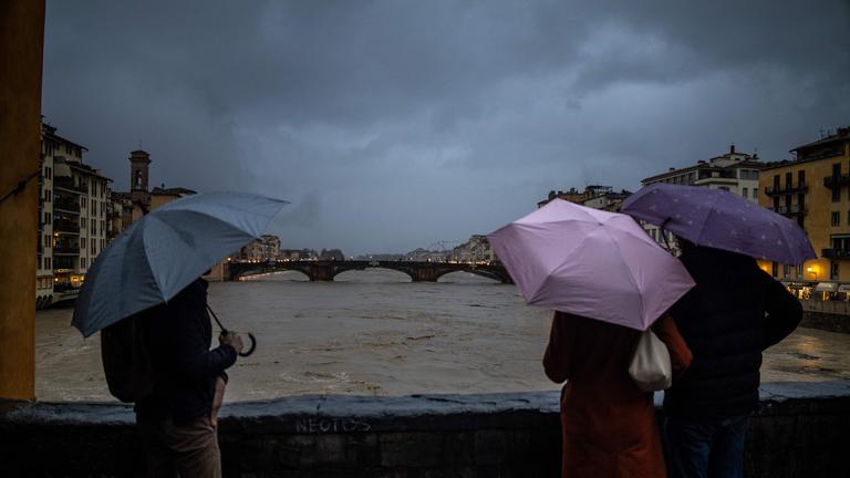 Menschen betrachten den steigenden Pegel des Flusses Arno in Florenz