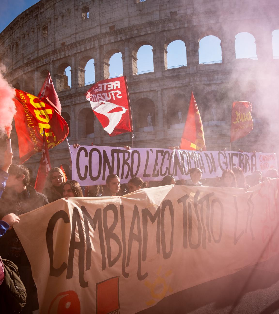 12.12.2025, Italien, Rom: Teilnehmer einer Demonstration unter anderem gegen das Haushaltsgesetz der Regierung sind in Rom auf einer Straße unterwegs.